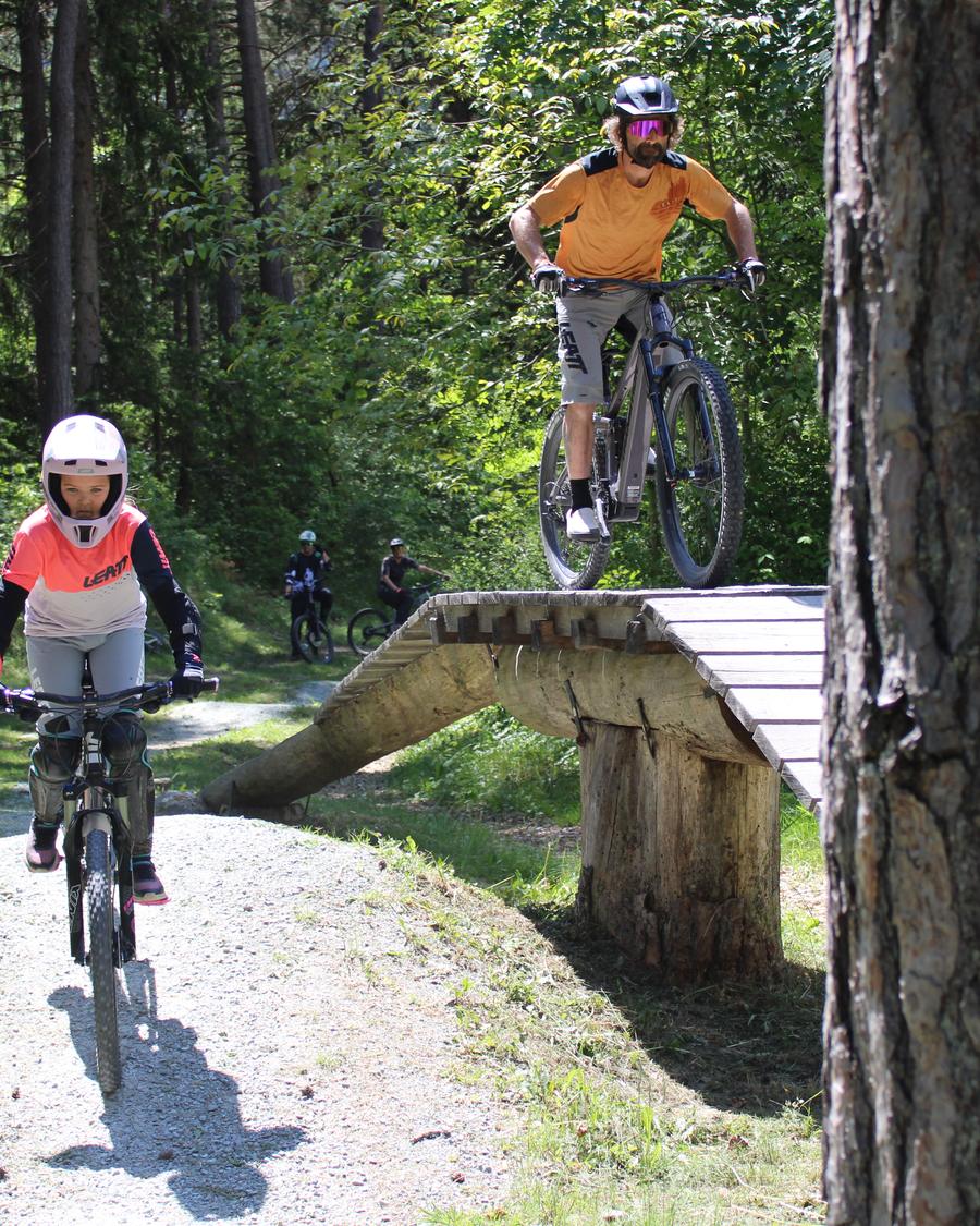 Junge Bikerin und Biker an einem Holzelement