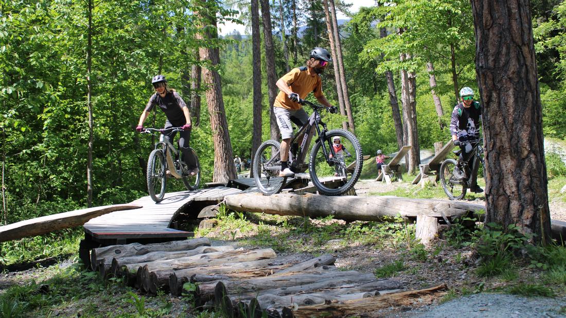 Biker balanciert über liegende Baumstämme